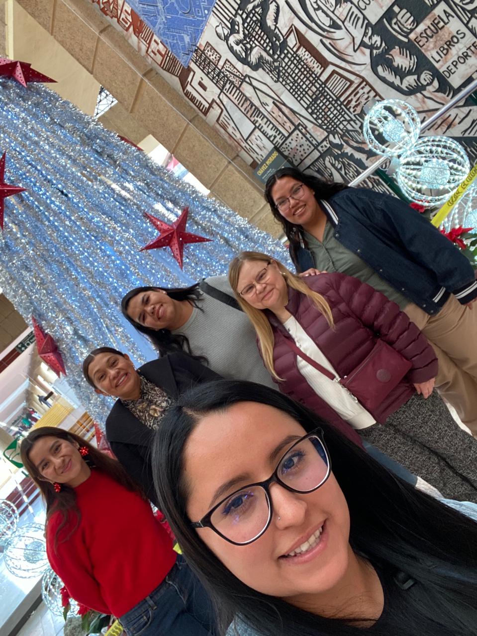 Celebración navideña en el laboratorio con mural decorativo